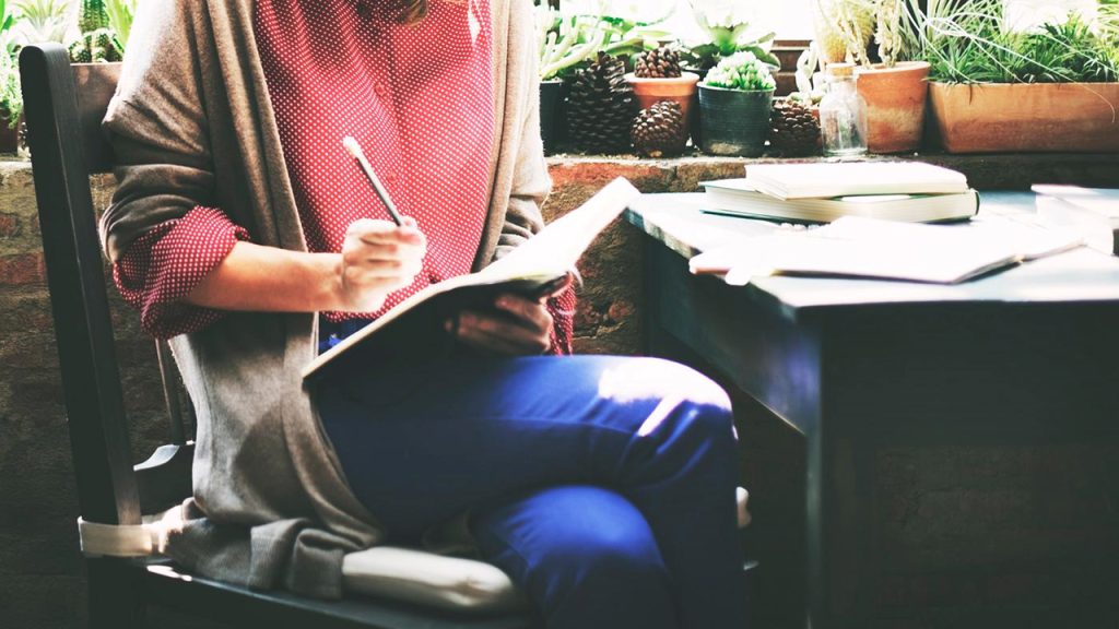 A vibrant image of a person journaling by a sunny window, symbolizing self-reflection and goal setting.